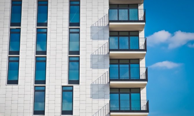 light colored apartment with shadows showing off of the balconies 